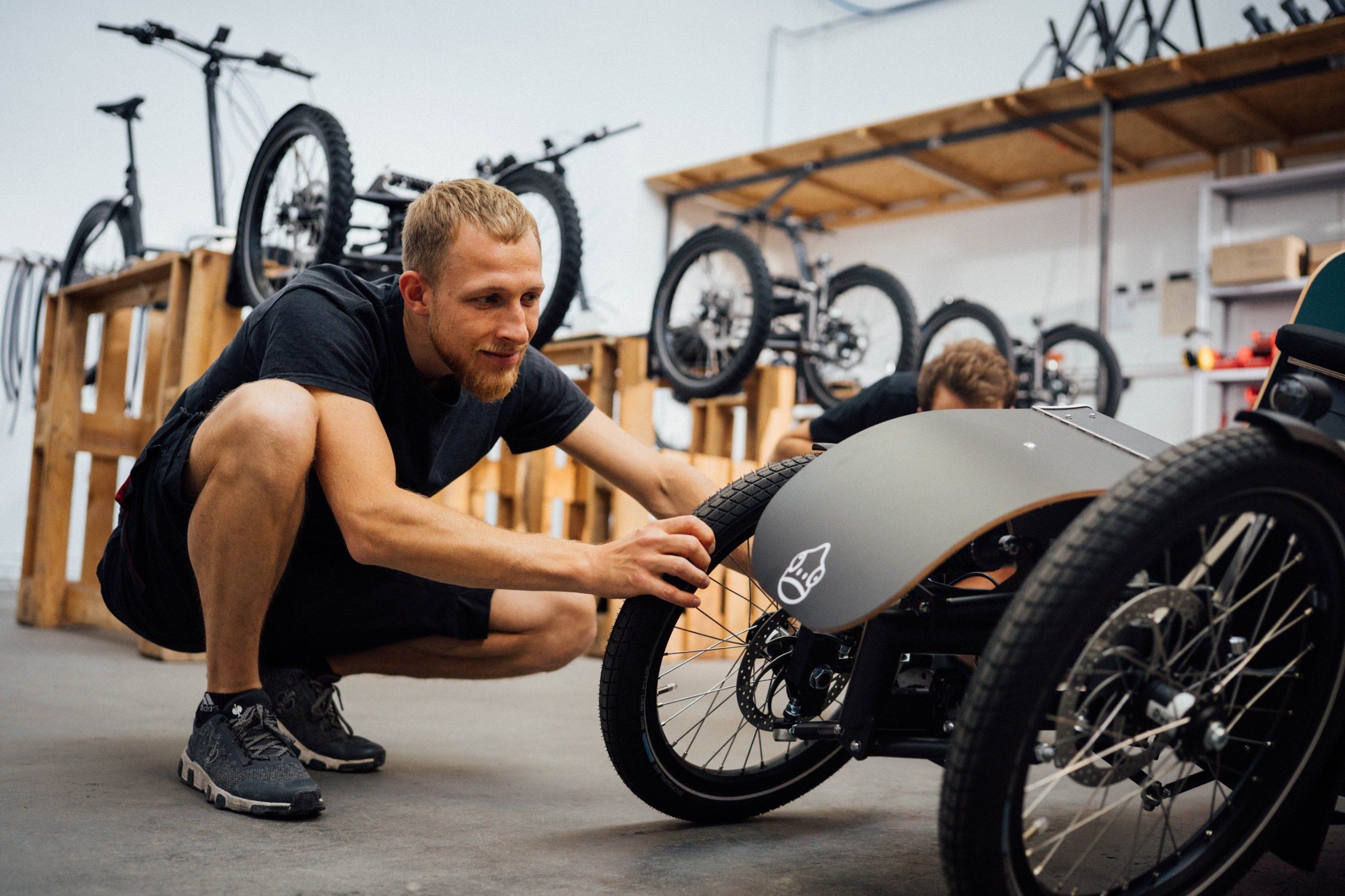Mechaniker prüft das Vorderrad eines Lastenrads